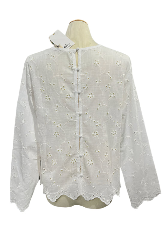 White lace blouse on a mannequin in a store setting