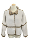 White jacket with brown trim on a mannequin in a store setting