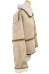 Beige coat with white trim on a mannequin in an indoor setting
