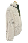 Fluffy white jacket with floral patterns on a mannequin in an indoor setting.