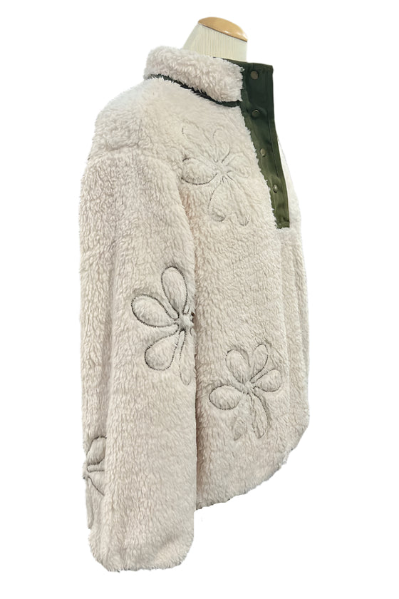 Fluffy white jacket with floral patterns on a mannequin in an indoor setting.
