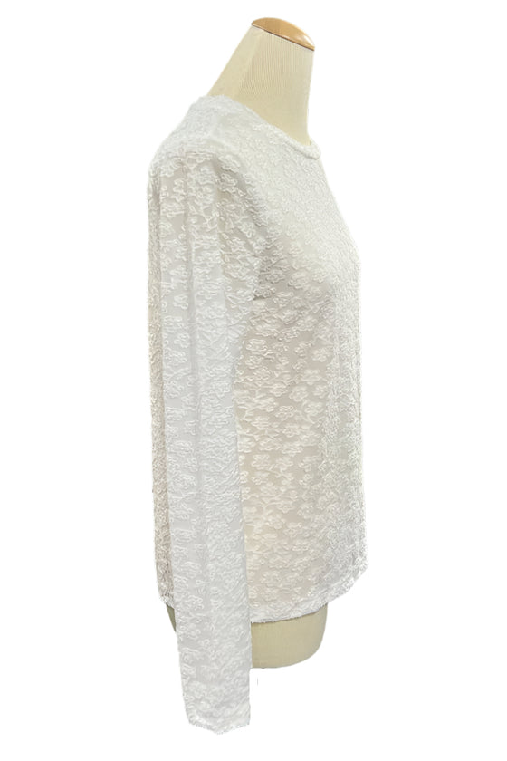 White textured sweater on a mannequin in a store setting