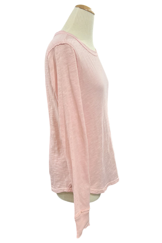 Pink long-sleeve top on a mannequin in a store setting