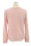 Pink long-sleeve shirt on a mannequin with a blurred indoor background
