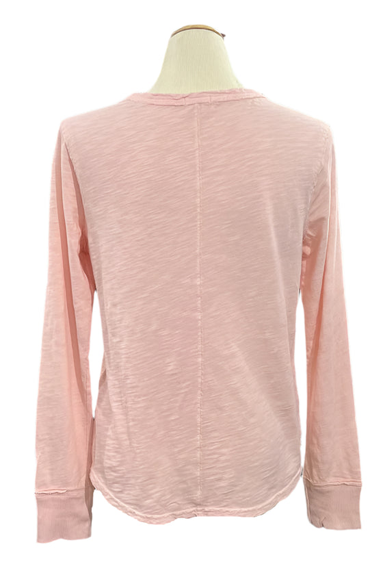 Pink long-sleeve shirt on a mannequin with a blurred indoor background