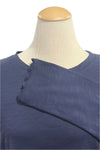 Navy blue shirt on a mannequin with a blurred indoor background