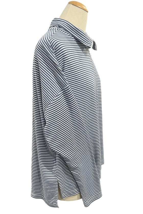 Striped shirt on a mannequin in a store setting with shelves and other clothing in the background.
