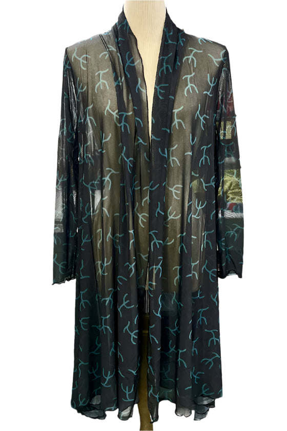 Black sheer cardigan with white floral pattern on a mannequin against a blurred outdoor background