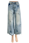 Blue jeans with star patches on a mannequin in a room setting.