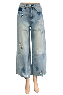  Blue jeans with star patches on a mannequin in a room setting.
