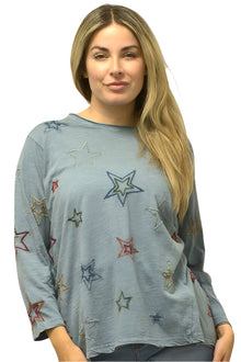  Woman wearing a blue long-sleeve top with star patterns on a plain background
