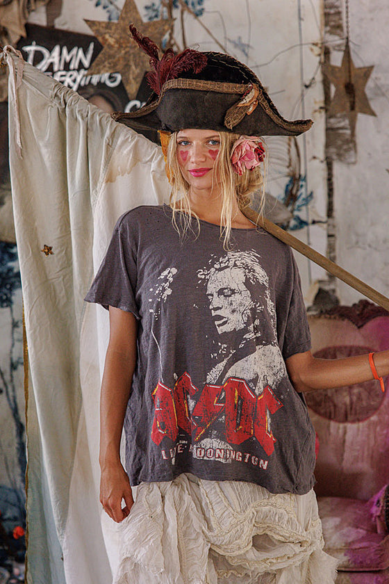 Person wearing a pirate hat and AC/DC t-shirt in a rustic setting