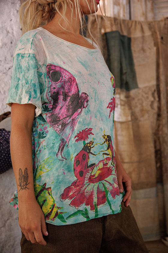 Person wearing a colorful t-shirt with artistic designs in a casual setting