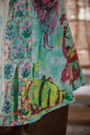 Colorful patterned dress with animals and floral designs on a blurred background
