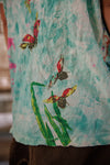 Close-up of a sleeveless shirt with colorful butterfly design on a light blue background
