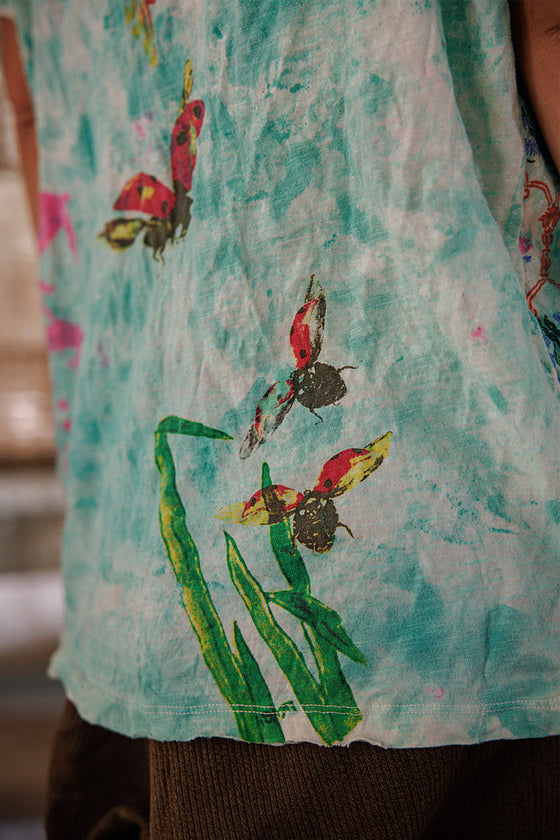 Close-up of a sleeveless shirt with colorful butterfly design on a light blue background
