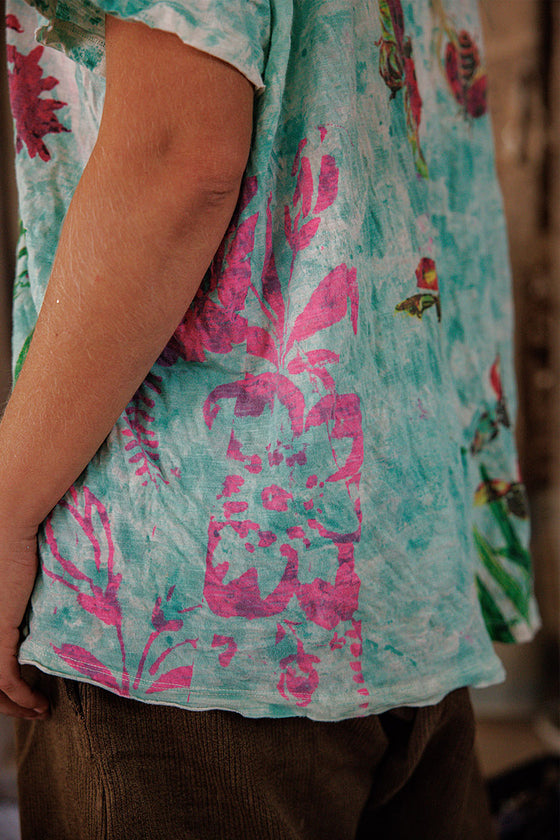 Person wearing a floral shirt with pink and green patterns.