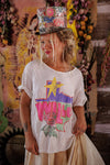 Person wearing a colorful top hat and graphic t-shirt with a star design, standing against a vibrant background.