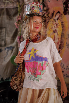  Young girl wearing a colorful top hat and graphic t-shirt with a patterned bag.