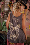 Person wearing a tank top with butterfly design and 'Nagging Pearl' text, standing in a decorative setting.
