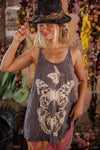 Woman wearing a tank top with butterfly designs in a floral setting