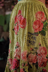 Yellow dress with pink floral embroidery and text on a blurred background