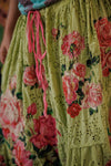 Floral embroidered skirt with pink tassels on a blurred background