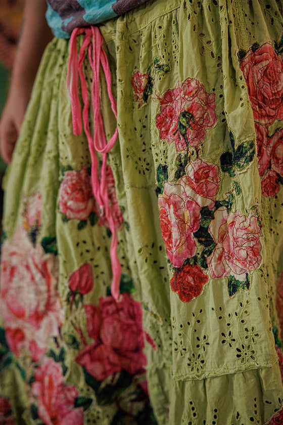 Floral embroidered skirt with pink tassels on a blurred background