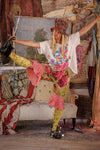 Person in colorful outfit posing in a room with eclectic decor