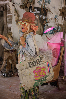  Person in a rustic setting holding a tote bag with 'Cose' branding