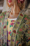 Woman wearing a colorful floral jacket with a blurred background