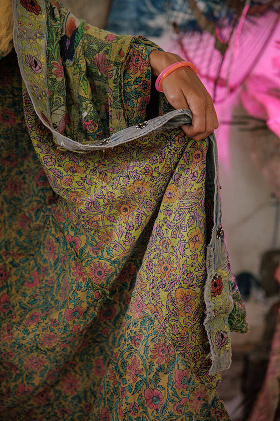Person wearing a colorful floral dress with a blurred background