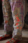 Patchwork pants with floral embroidery and red shoes on a blurred background