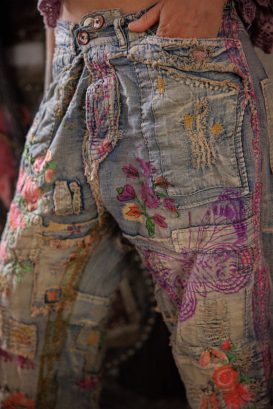 Close-up of embellished jeans with floral and butterfly patterns.