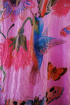 Colorful fabric with floral and bird design on a pink background