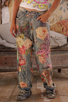  Person wearing floral patchwork jeans in a casual setting.