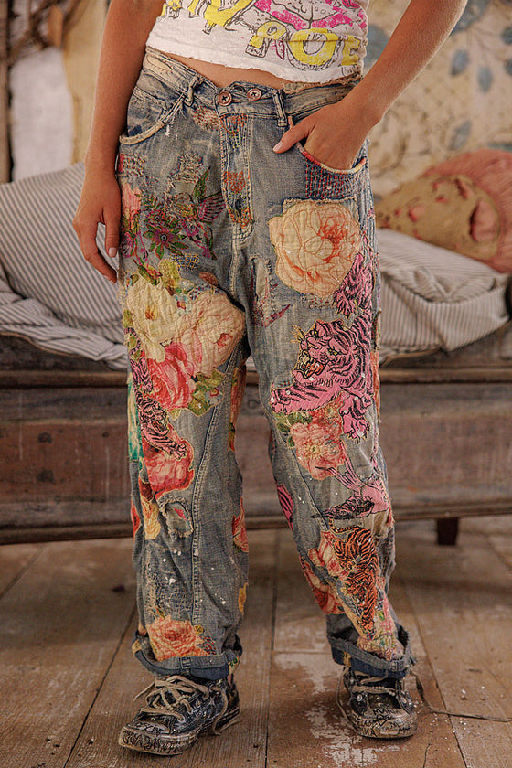 Person wearing floral patchwork jeans in a casual setting.