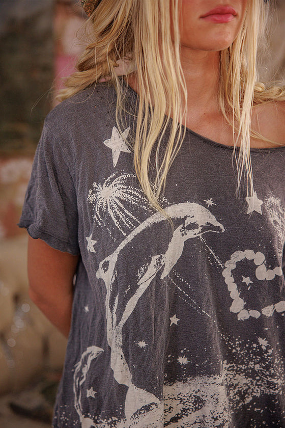 Person wearing a dark gray t-shirt with dolphin and star design.