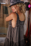 Woman wearing a gray dress and hat in a casual setting
