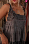 Woman wearing a dark gray dress with lace details in an indoor setting