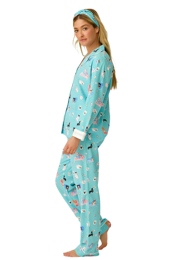 Woman wearing a teal pajama set with animal print on a white background