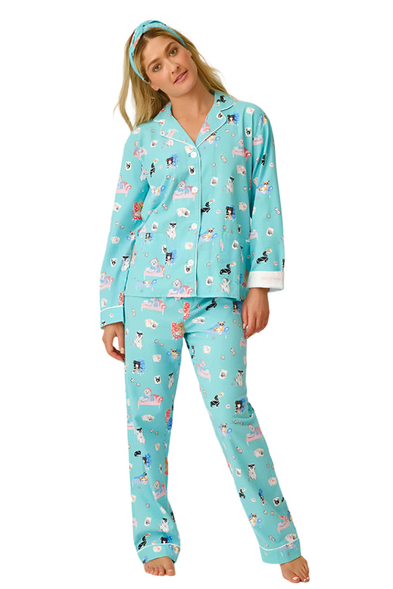 Woman wearing a blue pajama set with animal print on a white background
