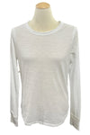 White long-sleeve shirt on a mannequin in a room with blurred background