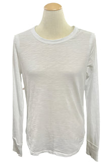  White long-sleeve shirt on a mannequin in a room with blurred background