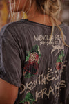 Person wearing a dark gray t-shirt with graphic designs and text.