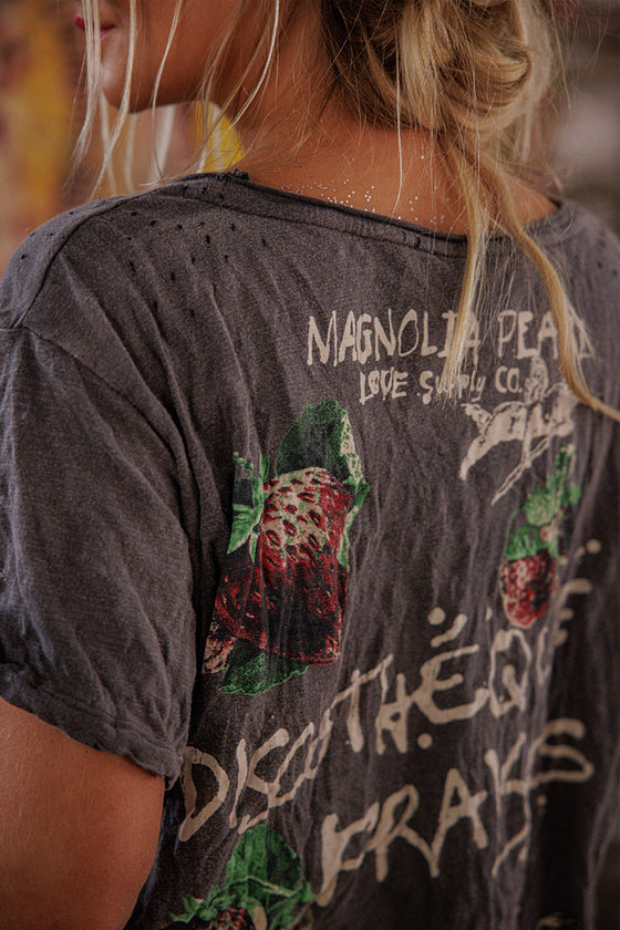Person wearing a dark gray t-shirt with graphic designs and text.