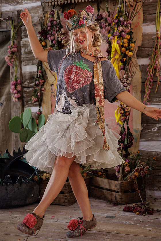 Person in a rustic setting with floral decorations and a cactus plant.