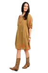 Woman wearing a copper dress with coral  floral embroidery on a white background