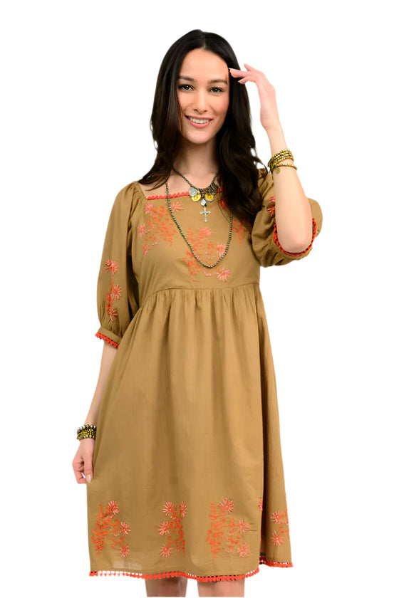 Woman wearing a copper dress with coral  floral embroidery on a white background