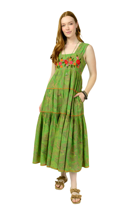 Woman wearing a green dress with floral embroidery on a white background